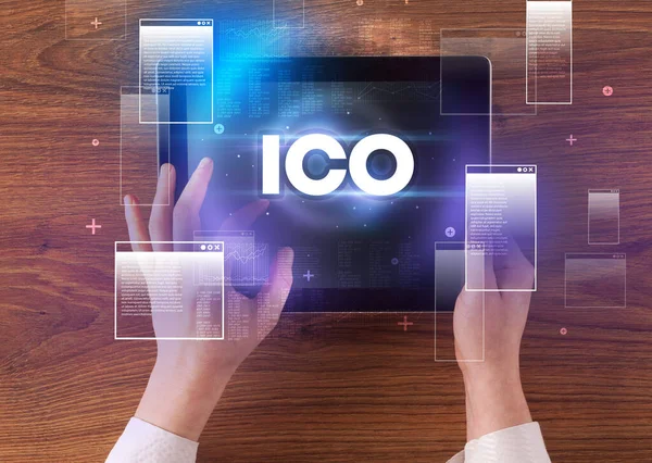 stock image Close-up of a hand holding tablet with ICO abbreviation, modern technology concept