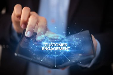 Müşteri Sözleşmesi ile birlikte katlanabilir bir akıllı telefon tutan bir iş adamı, yeni iş konsepti