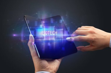 Biyoteknoloji yazıtlı, katlanabilir akıllı telefonu olan bir iş adamı, yeni teknoloji konsepti