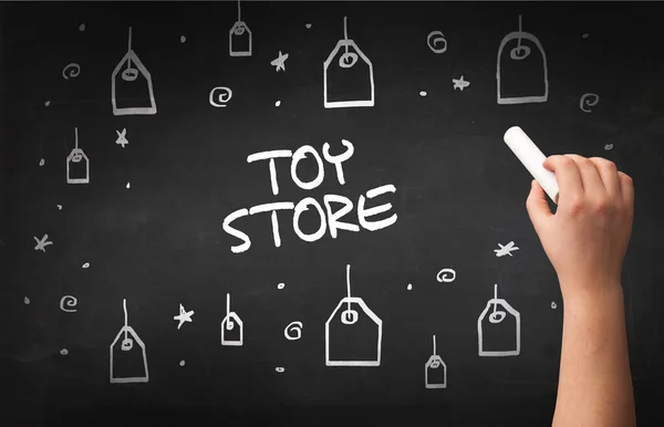 Hand drawing TOY STORE inscription with white chalk on blackboard, online shopping concept