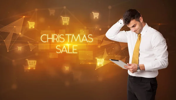 ショッピングカートのアイコンとクリスマスの販売の碑文を持つビジネスマン オンラインショッピングコンセプト — ストック写真