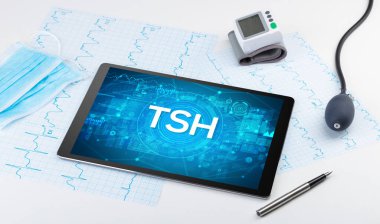 Close-up view of a tablet pc with TSH abbreviation, medical concept clipart