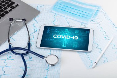 COVID-19 yazıtlı tablet bilgisayar ve doktor araçları, koronavirüs kavramı