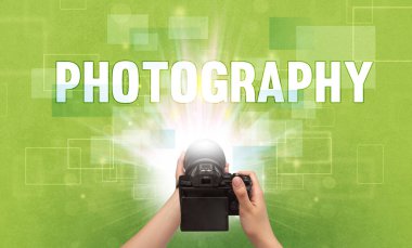 Fotografik yazı ve seyahat konseptiyle el ele tutuşan dijital kameranın yakın çekimi