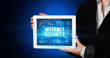 Tablet üzerinde çalışan genç iş adamı dijital işareti gösteriyor: INTERNET GÜVENLİĞİ
