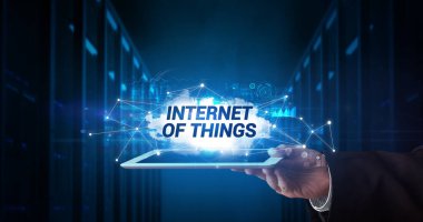 Tablet üzerinde çalışan genç iş adamı ve yazıtı gösteriyor: Nesnelerin İnterneti