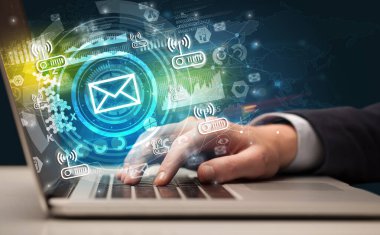 Multimedya ekranından gelen zarf simgesiyle modern bir dizüstü bilgisayarda el yazısı, sezgisel teknoloji kavramı