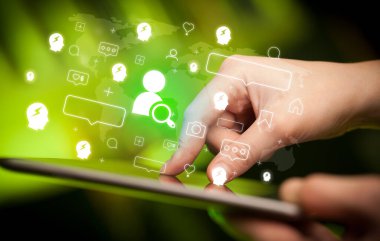 Tablet kullanan bir elin yakın plan görüntüsü, arama yapan insanların simgeleri, sosyal medya kavramı