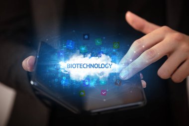 İş adamı elinde katlanabilir bir akıllı telefon tutuyor. Biyoteknoloji yazıtları, teknoloji konsepti...