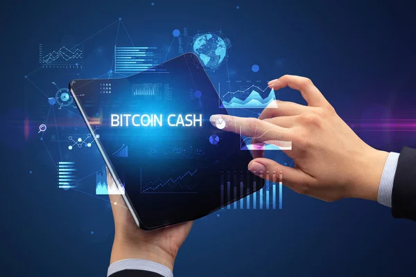 拥有可折叠智能手机的商人 有Bitcoin Cash的签名 成功的商业概念 — 图库照片