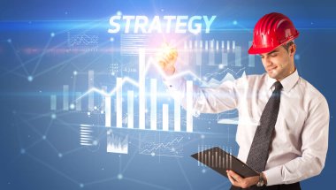 Kask çizen yakışıklı iş adamı STRATEGY yazıt, mimarlık iş planı konsepti