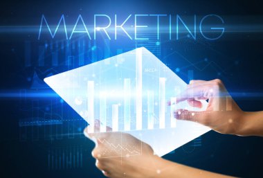 Üzerinde MARKETING yazıtları olan el ele tutuşan fütürist tablet, modern iş kavramı