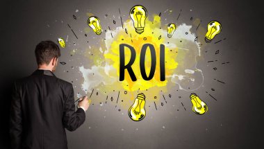 İş adamı ROI kısaltması ile renkli ampul çiziyor, yeni teknoloji fikri