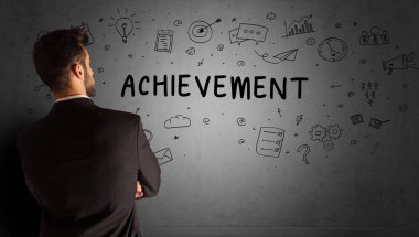 İş adamı, ACHIEvEMENT yazıtları ve iş stratejisi konseptiyle yaratıcı bir fikir çizimi yapıyor.