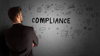 İş adamı, COMPLIANCE yazıtları ve iş stratejisi konseptiyle yaratıcı bir fikir çizimi yapıyor.