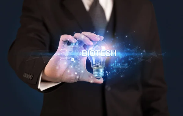 Бизнесмен Держит Лампочку Надписью Biotech Концепция Инновационных Технологий — стоковое фото
