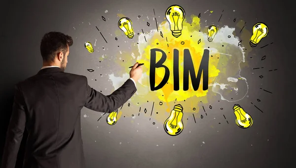 stock image businessman drawing colorful light bulb with BIM abbreviation, new technology idea concept