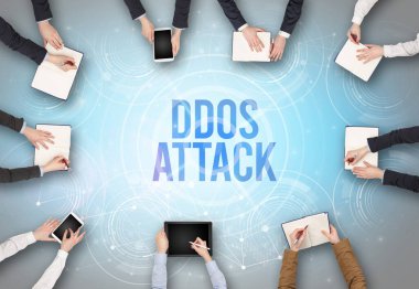 DDOS ATTACK insciption, web güvenlik kavramı olan bir dizüstü bilgisayarın önünde bir grup insan