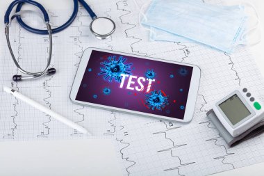 Beyaz yüzeyde TEST yazıtı, salgın konsepti içeren tablet pc ve doktor araçları