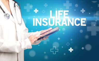 Doktor panoya LIFE INSURANCE yazısını, ilk yardım kavramını içeren notlar yazar