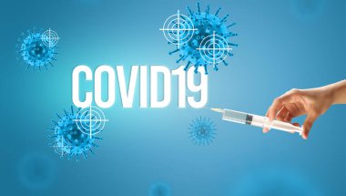Doktorların yakından görüntüsü elinde COVID19 yazılı bir şırınga olan beyaz bir eldiven, koronavirüs panzehiri konsepti.