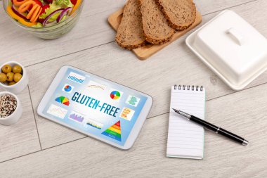 Organik gıda ve tablet bilgisayarı GLUTEN-FREE yazısını, sağlıklı beslenme bileşimini gösteriyor