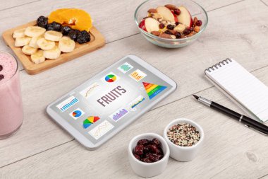 Organik gıda ve tablet. FRUITS yazısını, sağlıklı besin bileşimini gösteriyor.