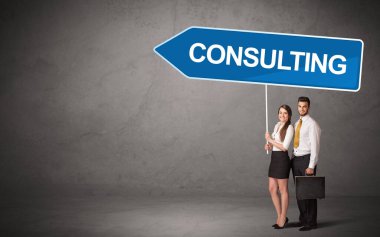 CONSULTING yazıtları, yeni iş yönü konsepti ile günlük bekleme yolu tabelasında genç iş adamı