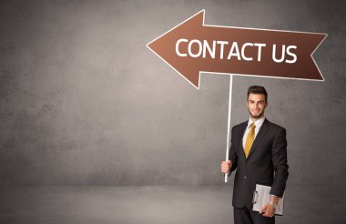 CONTACT ABD yazıtları, iş yönü konsepti ile günlük bekleme yolu tabelasında genç iş adamı