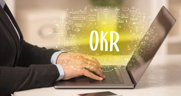 手作業でOkrの略語を持つ新しい近代的なコンピュータに取り組んで 近代的な技術の概念 — ストック写真