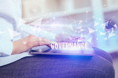 GOVERNANCE yazıtları ve modern iş teknolojisi kavramı olan tablet kullanarak elleri kapat
