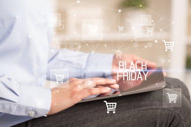 Genç kişi, Kara Cuma yazıtı ile online alışveriş uygulaması üzerinden alışveriş yapıyor