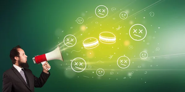 Young person shouting in megaphone and tasty macaron icon, healthy eating concept