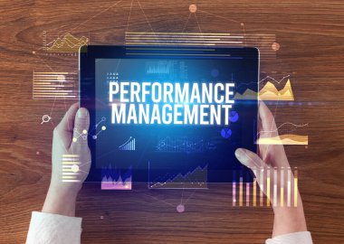 Performans Yönetimi yazılı tableti, modern iş konsepti olan ellerin yakın çekimi