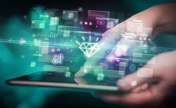 Close-up of a hand using tablet with diamond icons coming out from it, digital currency concept