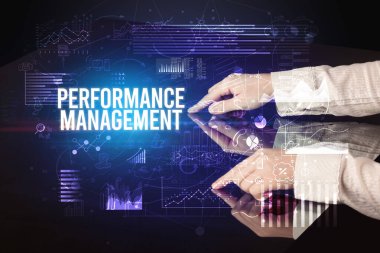 İş adamı Performans Yönetimi yazıtları ve siber iş konseptiyle büyük ekrana dokunuyor.