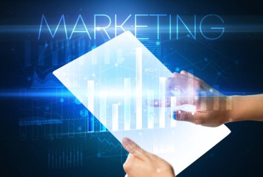 Üzerinde MARKETING yazıtları olan el ele tutuşan fütürist tablet, modern iş kavramı