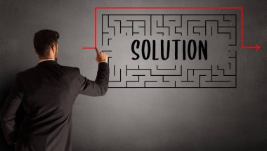 SOLUTION yazıtları ve iş eğitimi konseptiyle labirent çizen işadamı