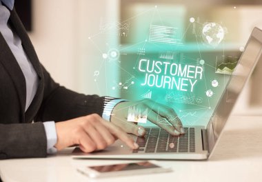 Bilgisayarda CUSTOMER JOURNEY yazıtları ve modern iş konseptiyle çalışan bir iş adamının yan görüntüsü