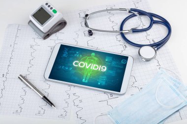 COVID19 yazıtları, koronavirüs kavramına sahip tablet bilgisayar ve doktor araçları