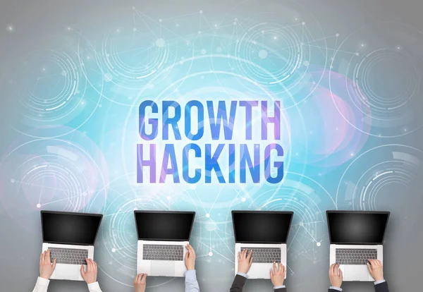 Group of people in front of a laptop with GROWTH HACKING insciption, web security concept