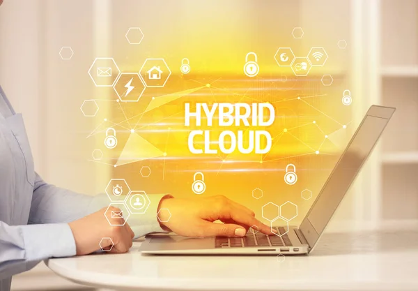 HYBRID CLOUD inscription on laptop, internet security and data protection concept, blockchain and cybersecurity