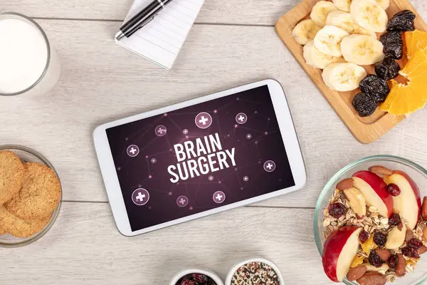 BRAIN SURGERY concept in tablet pc with healthy food around, top view