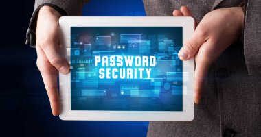 Tablet üzerinde çalışan genç iş adamı dijital işareti gösteriyor: PASSWORD GÜVENLİĞİ