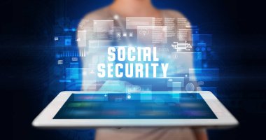 Tablet üzerinde çalışan genç iş adamı dijital işareti gösteriyor: SOSYAL GÜVENLİK