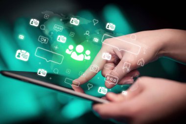 Toplum simgeleri içeren tablet kullanan bir elin yakın çekimi, sosyal medya kavramı