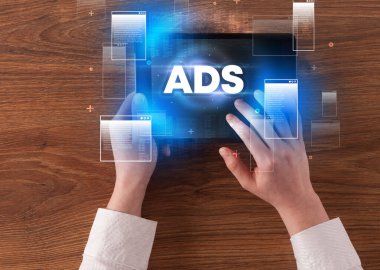 ADS kısaltması, modern teknoloji konsepti olan bir tabletin el ele tutuşması.