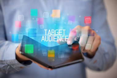 Katlanabilir bir akıllı telefon tutan genç adam TARGet AUDIENCE yazıtları, eğitim konsepti