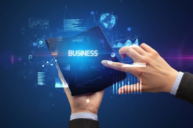 İş adamı elinde katlanabilir bir akıllı telefon tutuyor. İş dünyası yazıtları, başarılı bir iş konsepti.