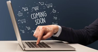 İş adamı dizüstü bilgisayarda Coming Soon yazıtı ve online alışveriş konseptiyle çalışıyor.